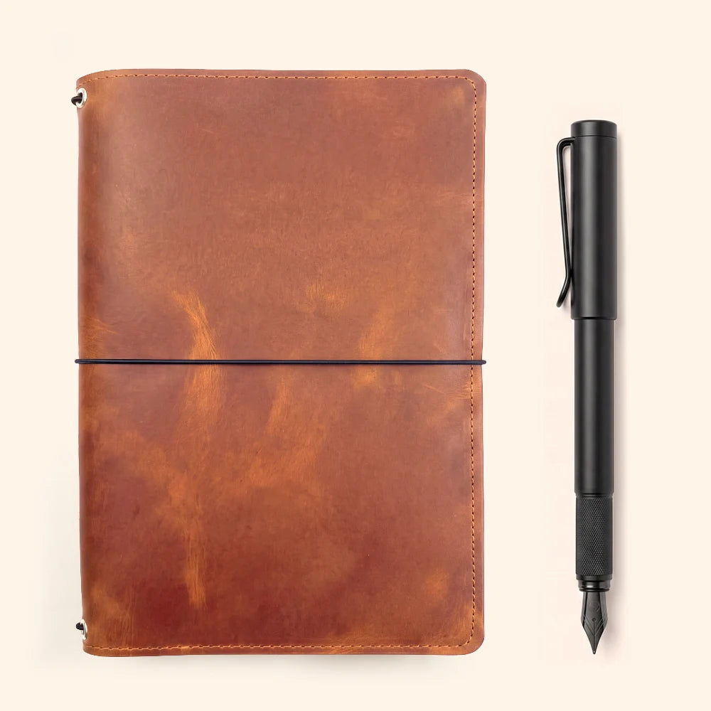 Handmade leather journal cover with three elastic straps for secure refill storage.