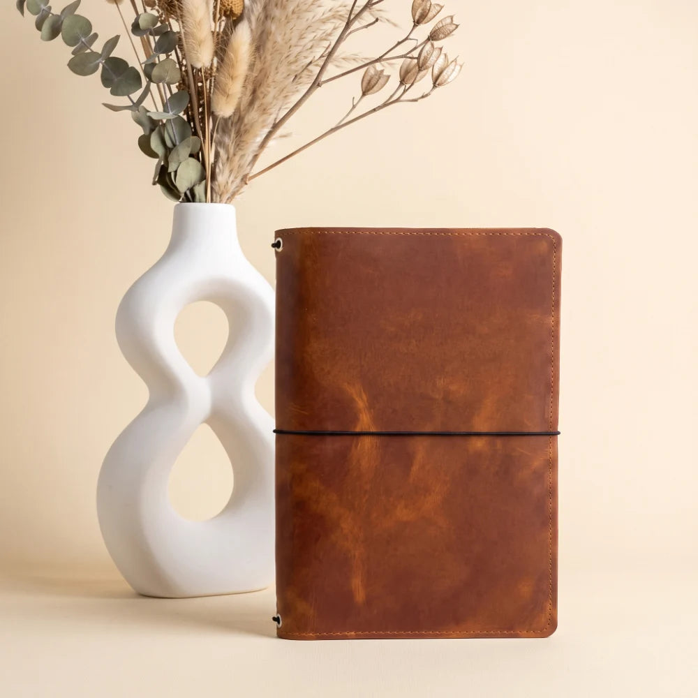 Elegant genuine leather notebook holder featuring three flexible elastic straps inside.