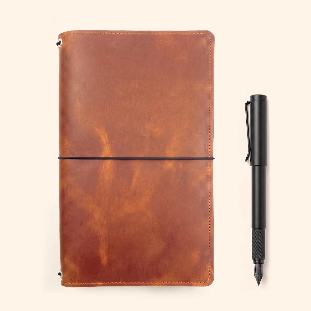Refillable leather journal sleeve designed to combine three notebooks in one cover.