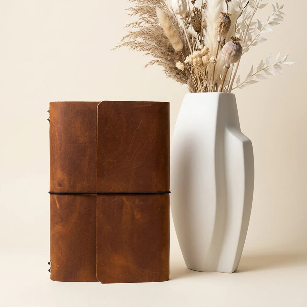 Reusable leather journal shell featuring six flexible bands for modular notebook storage.