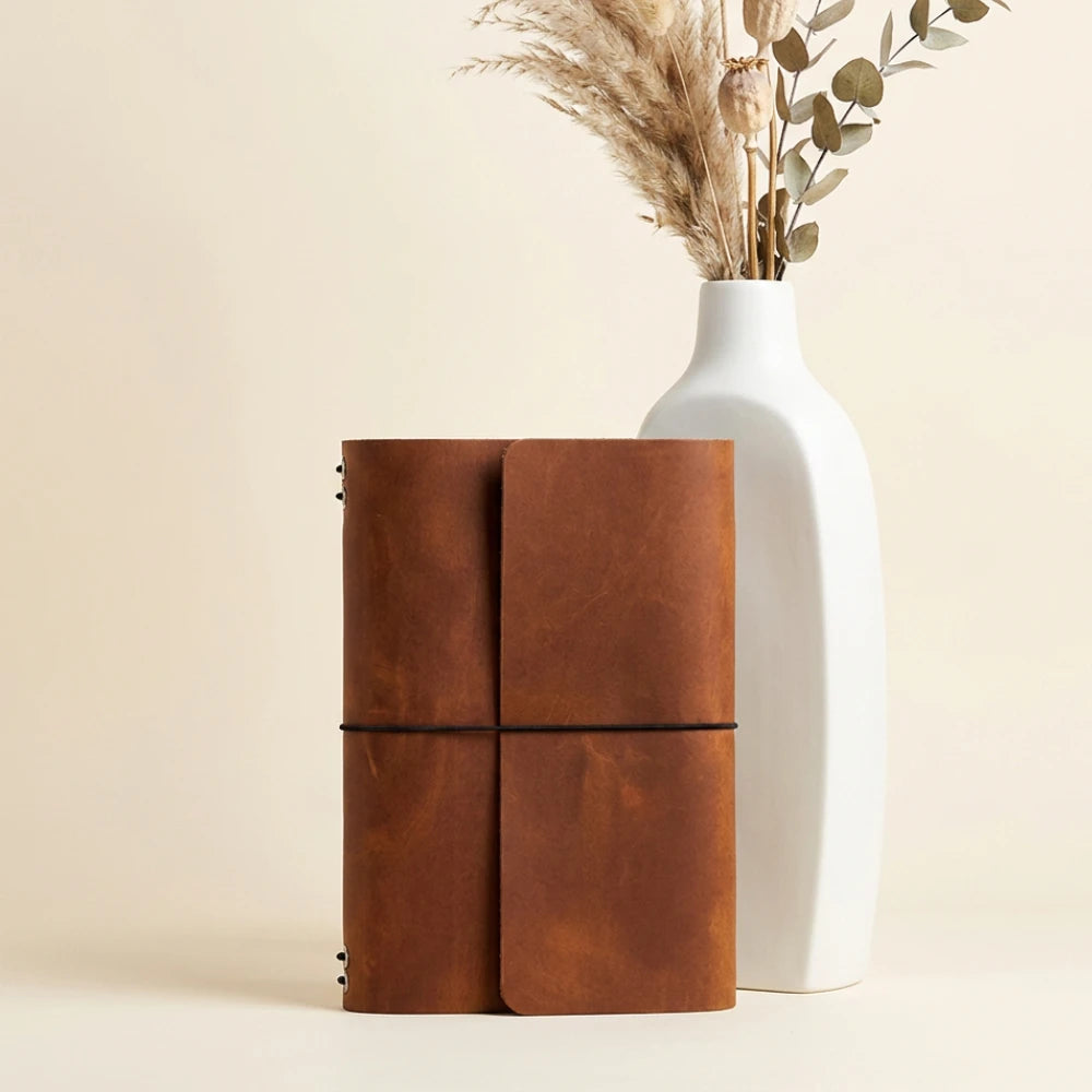 Natural leather notebook organizer designed with six bands for flexible journal storage.