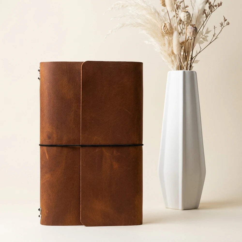 Leather travel notebook shell equipped with six elastic retainers for paper refills.
