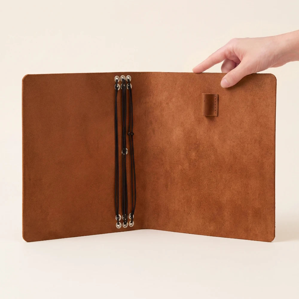 Refillable writing journal cover with six interior cords and an accessible pen loop.