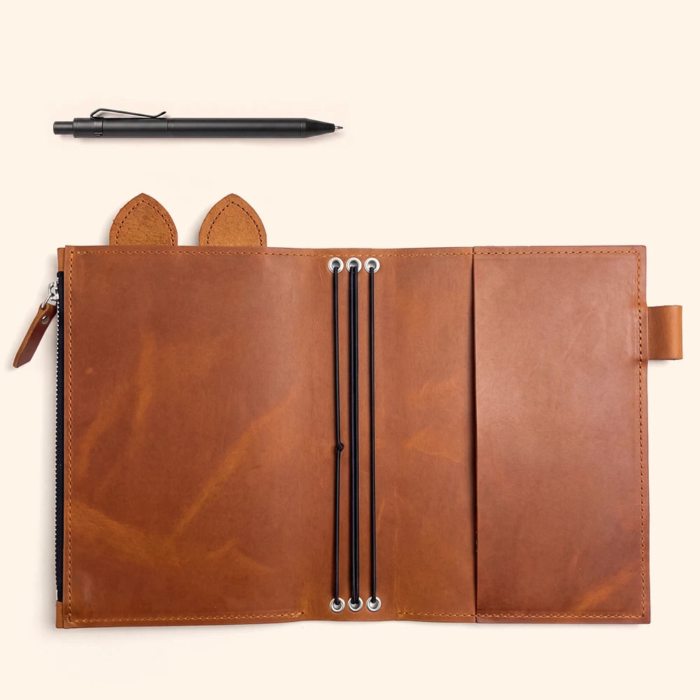 Handcrafted leather planner holder with three flexible bands and polished metal eyelets.