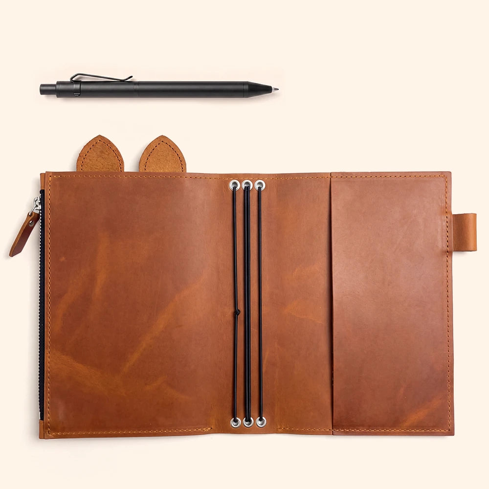 Handcrafted leather planner featuring polished metal eyelets and three vertical elastic cords.
