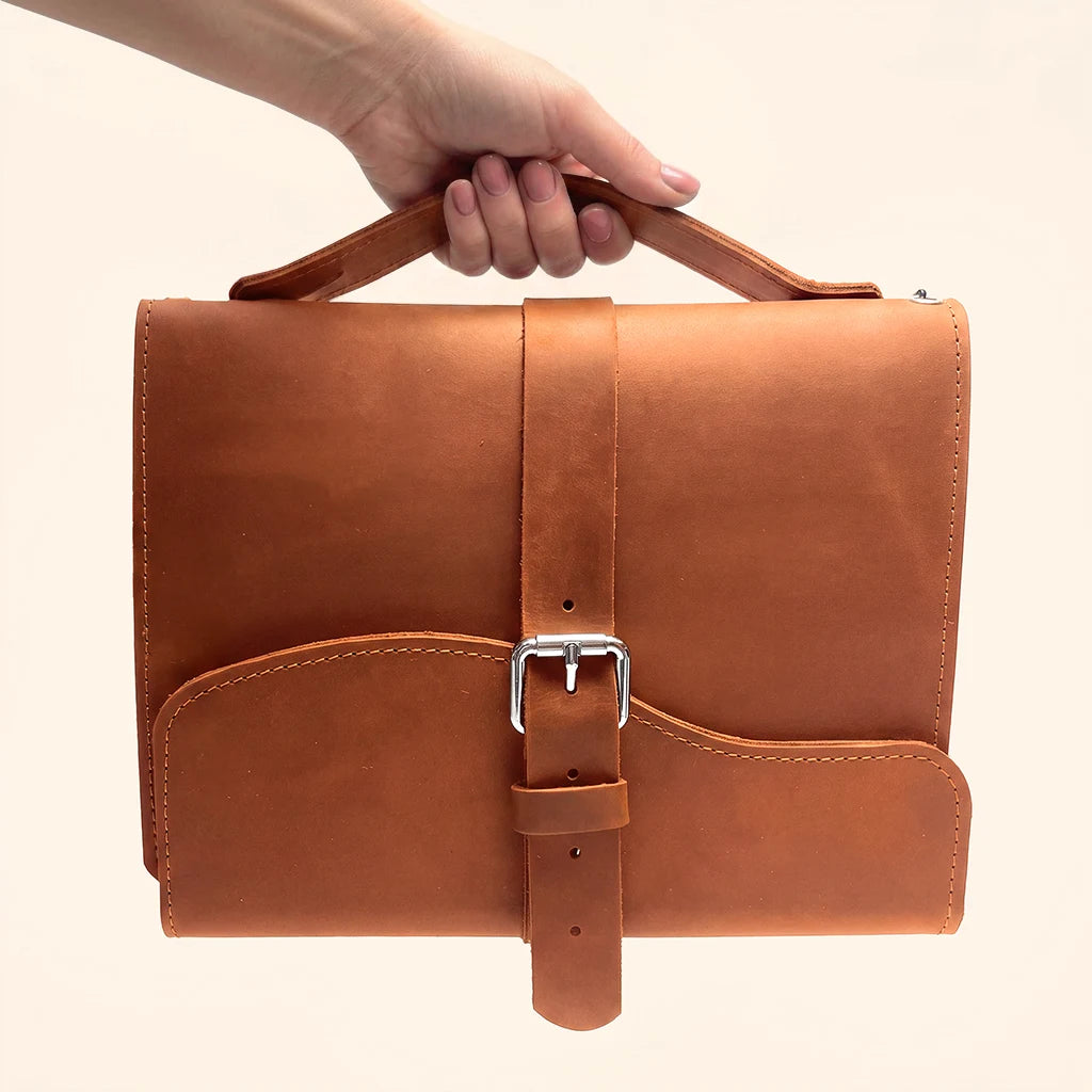 Leather notebook organizer featuring three elastic bands for holding multiple interchangeable inserts.