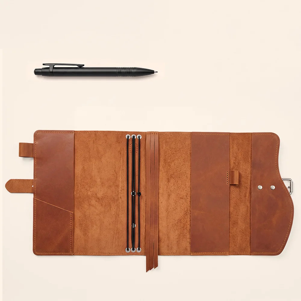 Leather notebook case showcasing interior pockets, pen loop, built-in bookmark, and practical handle for carrying.