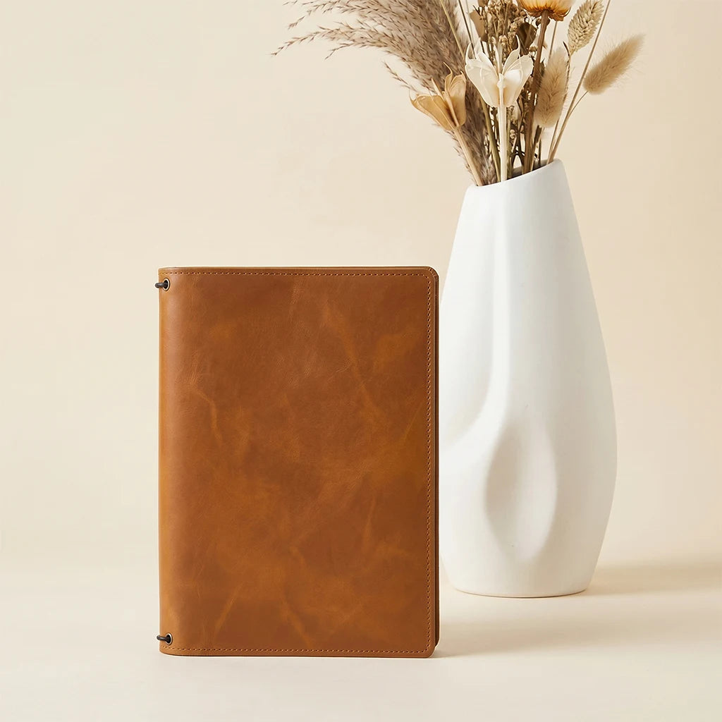 Minimalist leather journal cover with three elastic bands and pockets.
