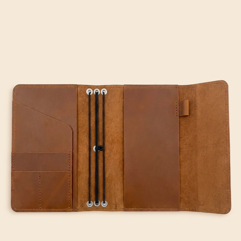 Leather journal cover featuring multiple elastic notebook holders and organizer pockets inside.