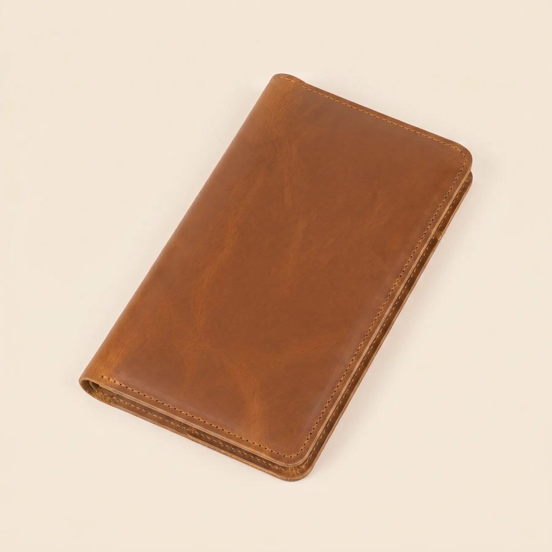 Long handcrafted leather wallet with snap fastening, cash pockets, and interior zipper coin compartment.