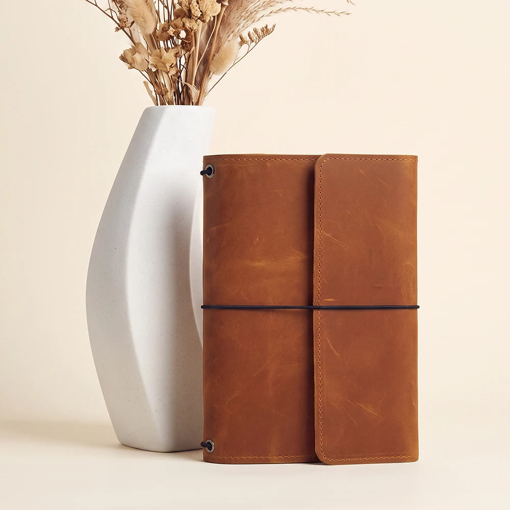 Handcrafted leather notebook organizer offering premium quality and secure refillable insert design.
