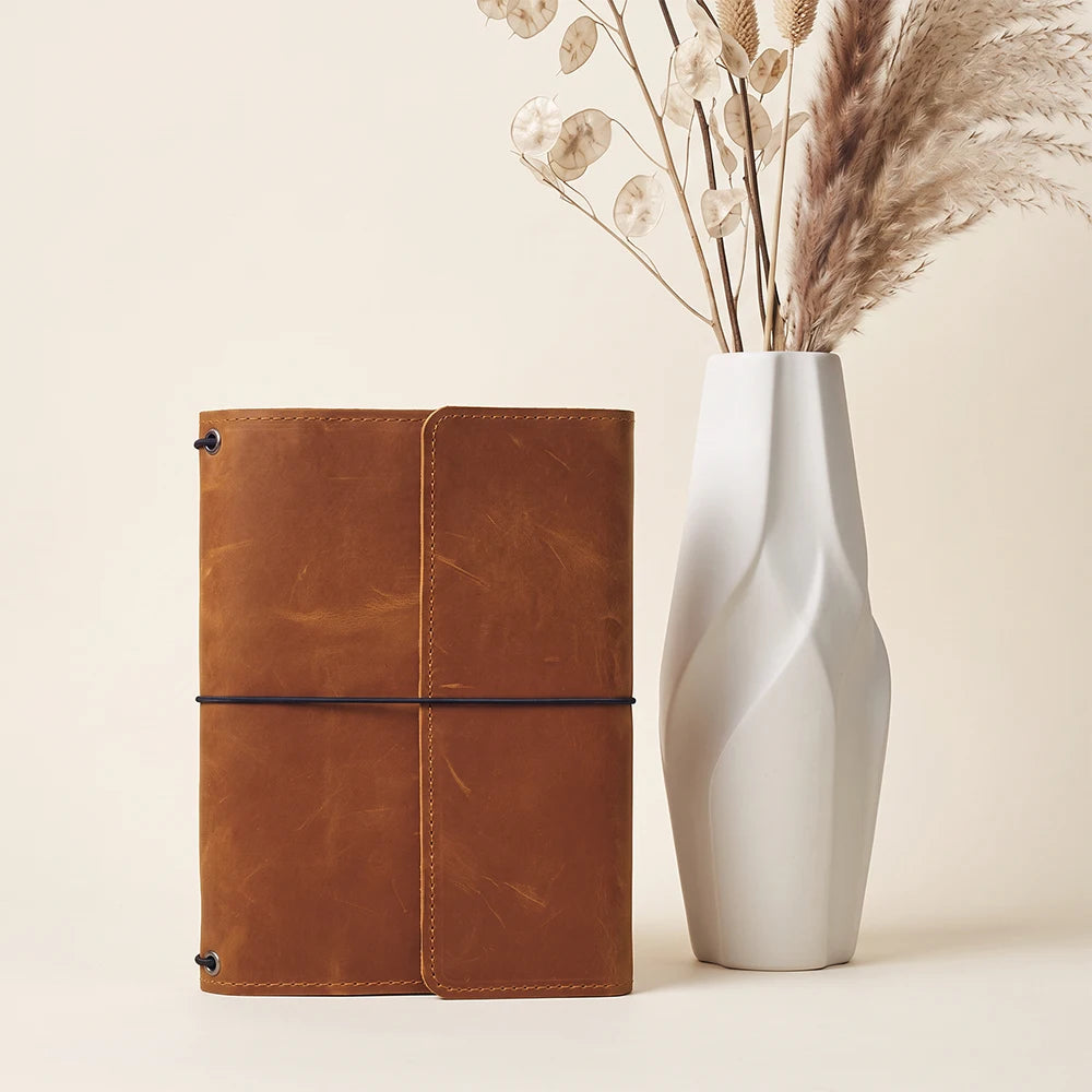 Handmade leather planner cover with refillable design and thoughtfully arranged interior pockets.