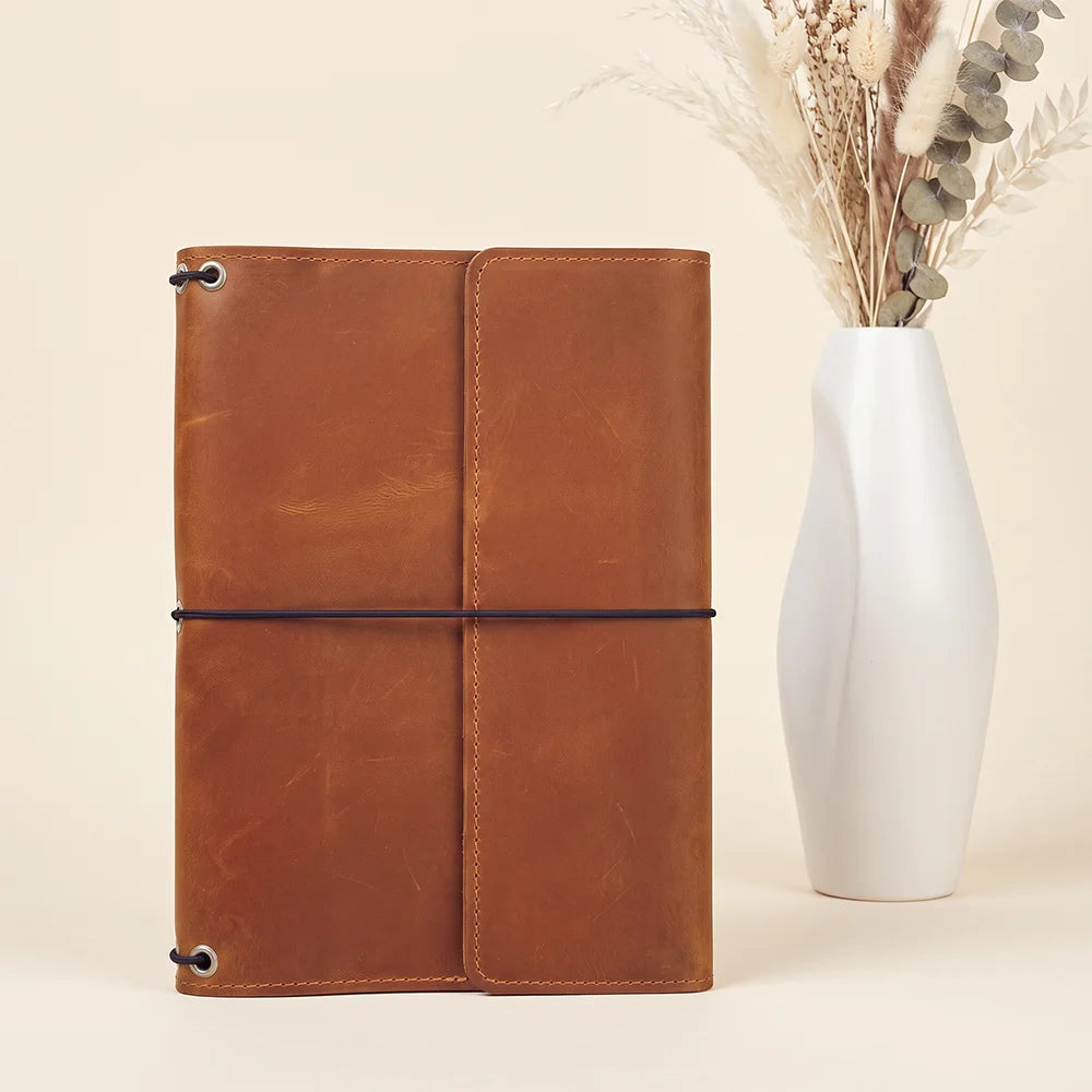 Genuine leather planner cover with organized interior layout and flexible notebook retention system.