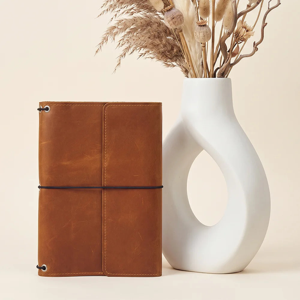 Handmade leather notebook cover with interior card pockets and three refillable elastic bands.
