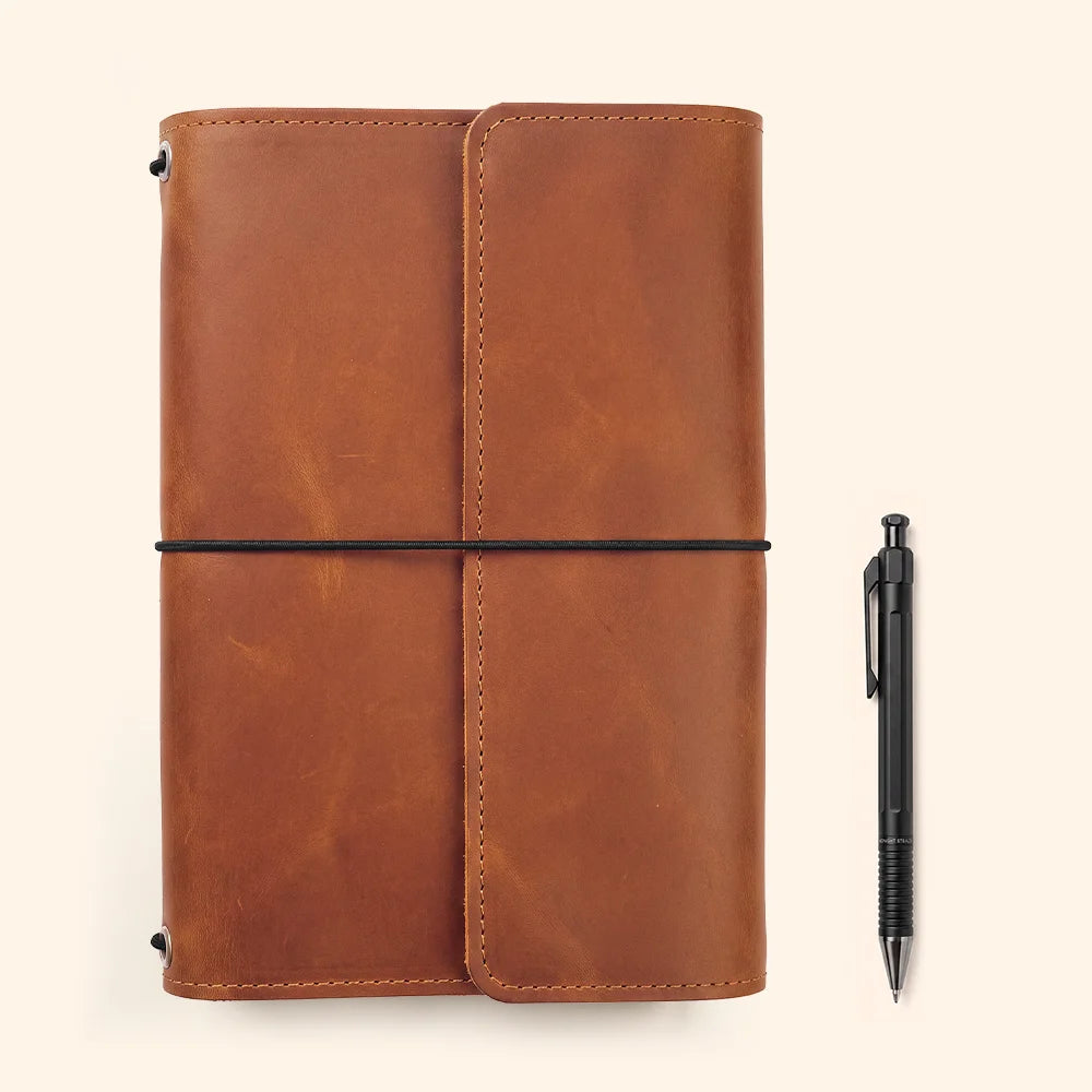Handmade leather planner case showcasing functional interior organization and a dedicated writing instrument loop.
