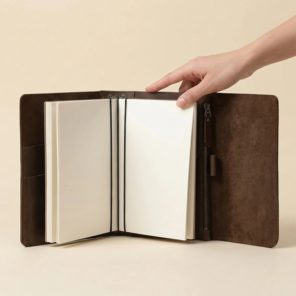 Leather travel notebook system featuring triple elastics and storage pockets.