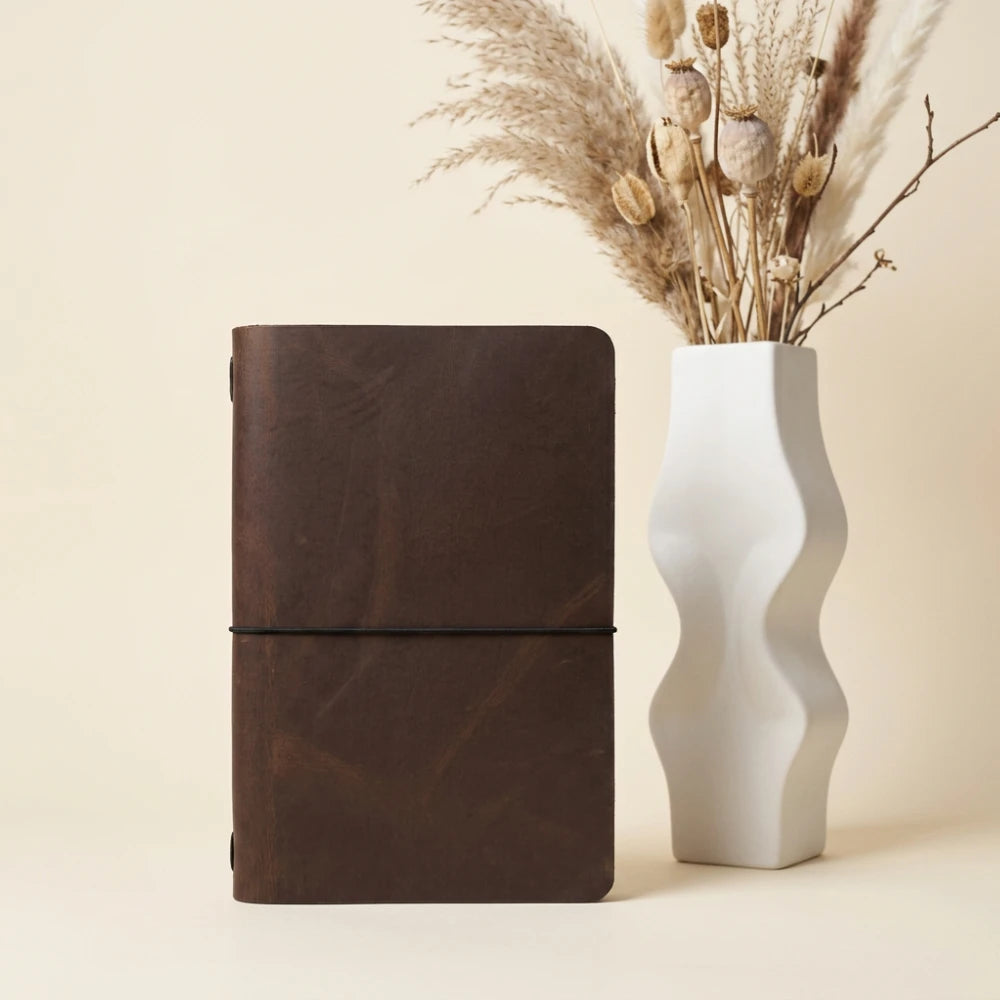 Handcrafted leather notebook holder offering simple storage for personal writing essentials.
