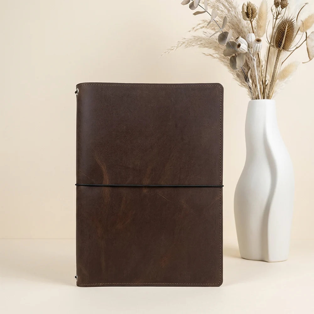 Leather refill cover with elastic attachment points and pockets for small paper items.