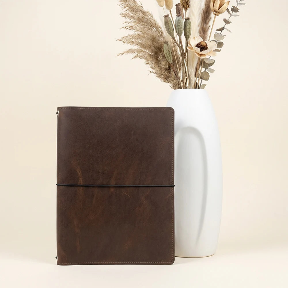 Refillable leather journal cover with organized pockets and secure three-band elastic system.