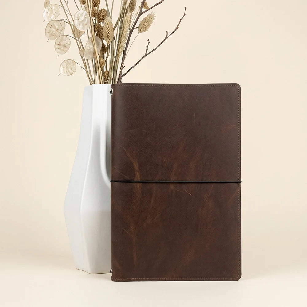 Handcrafted leather journal sleeve with separate compartments for notes, cards, and sketchbooks.