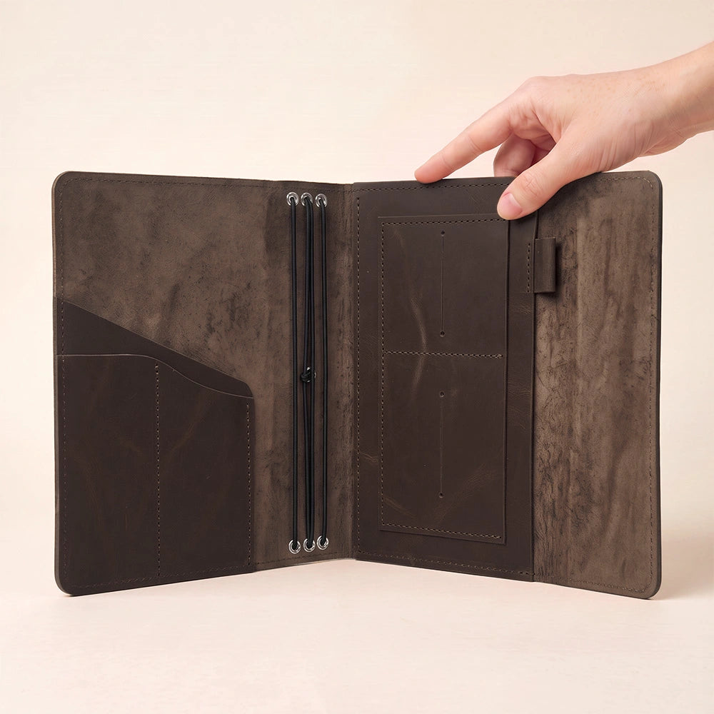 Leather writing journal cover designed with spacious inner pockets and integrated pen holder.