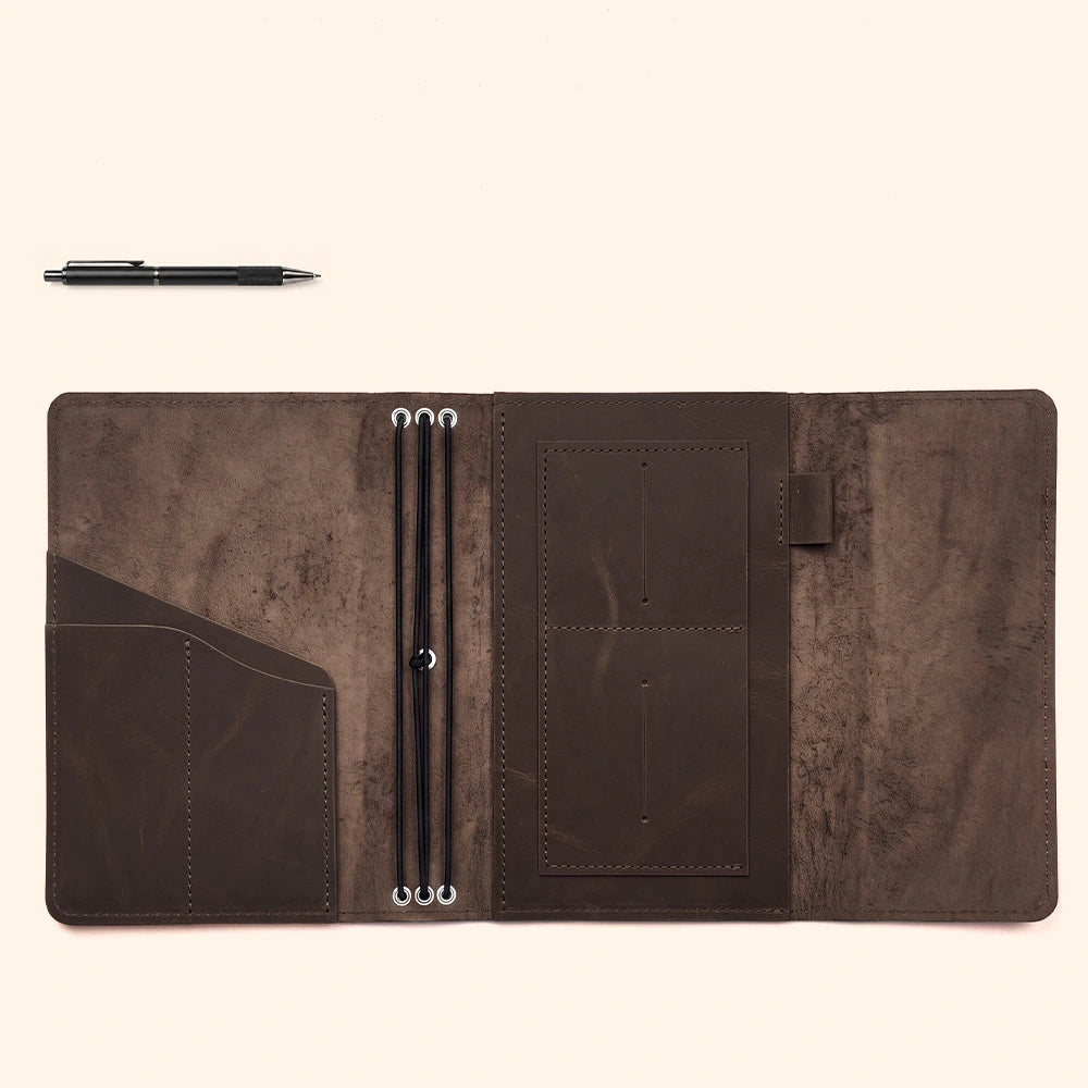 Artisan leather notebook cover with thoughtfully arranged interior pockets and reliable pen retaining loop.