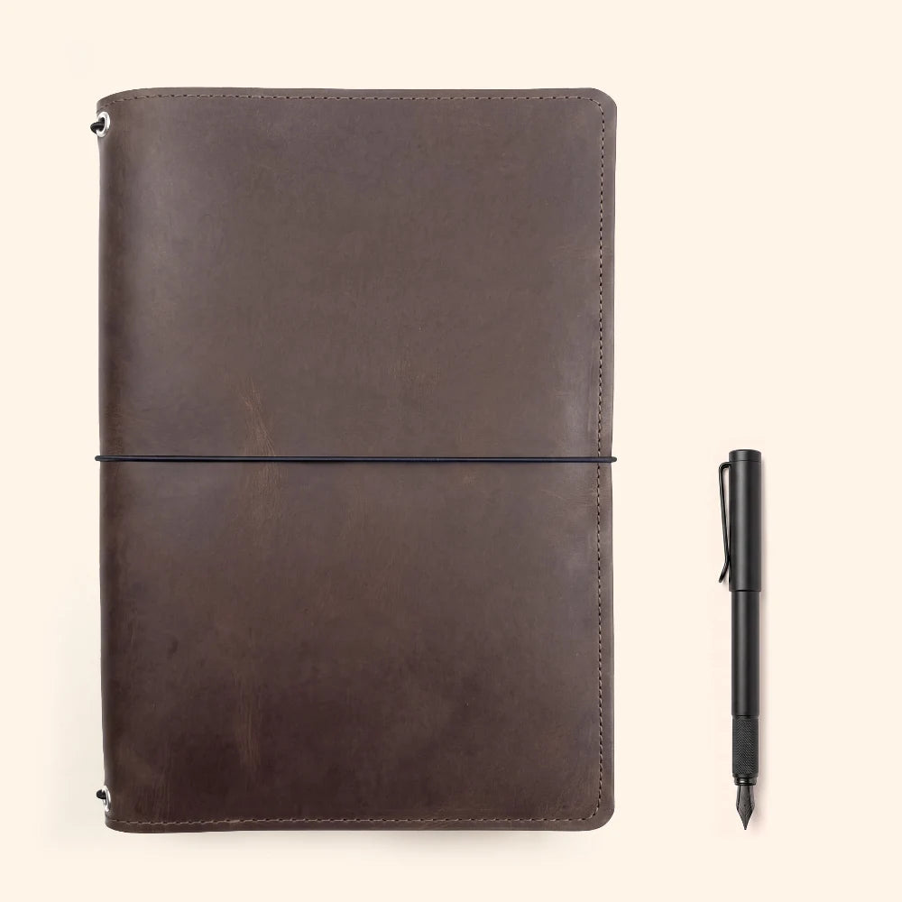 Handmade reusable leather cover for securely carrying three notebook booklets.
