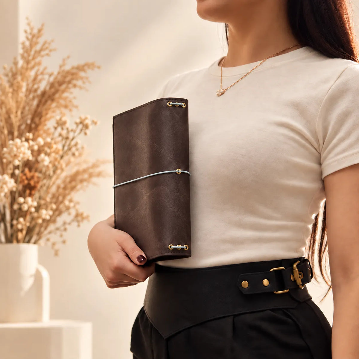 Female model showcasing a genuine leather journal cover with its distinctive textured surface.