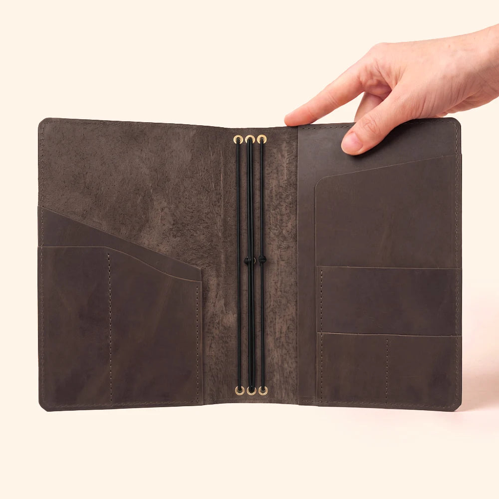Refillable notebook cover crafted from natural leather with three secure elastic straps.