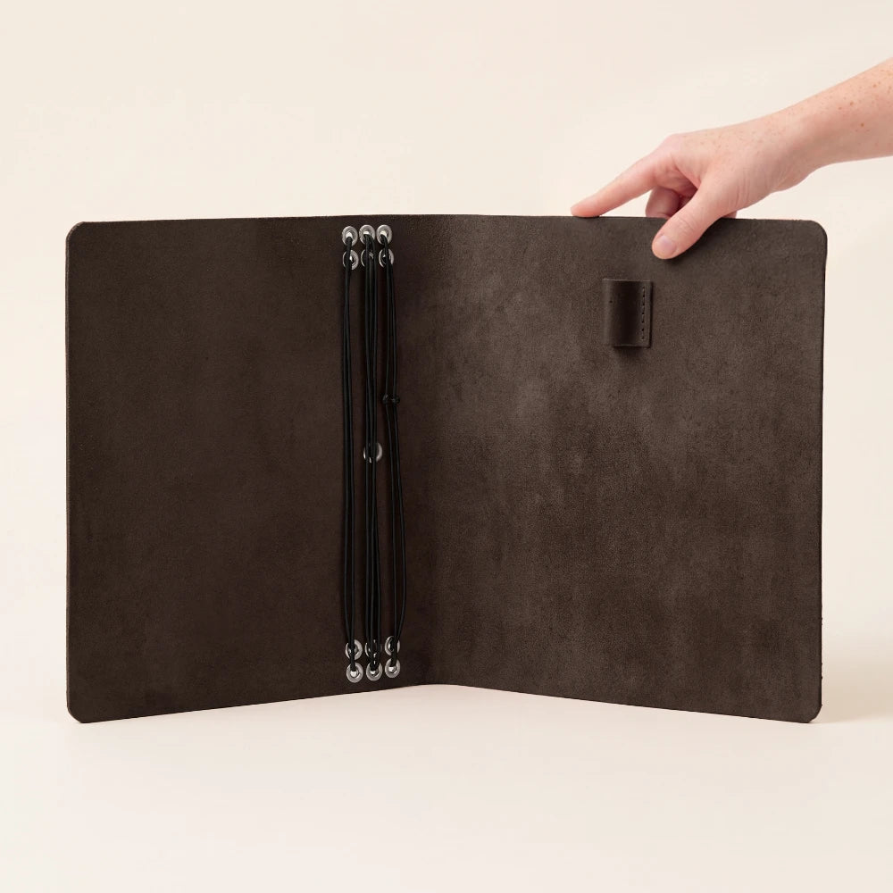 Handmade leather journal wrap featuring six elastic retainers for personalized notebook arrangements.