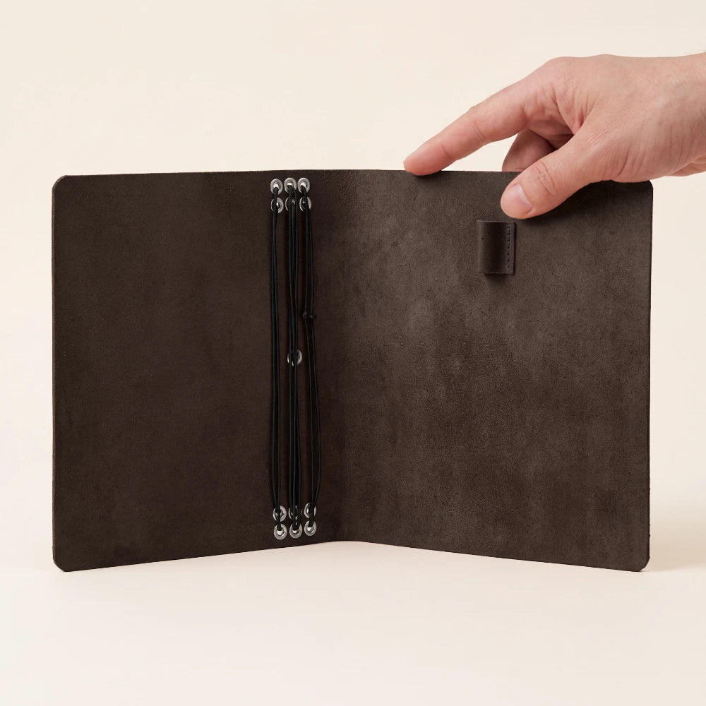Leather travel journal cover with six elastic bands and a functional pen loop.