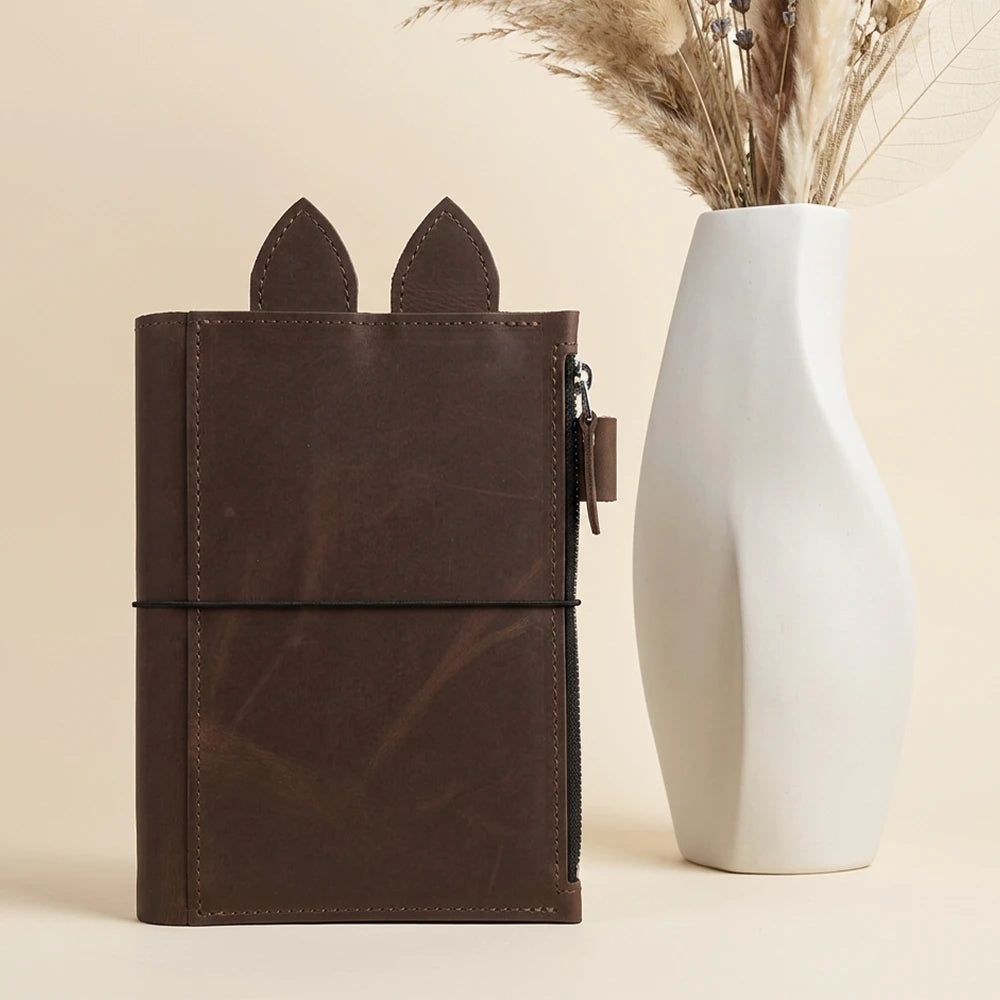 Handmade notebook organizer crafted from rich brown leather with playful decorative ears.
