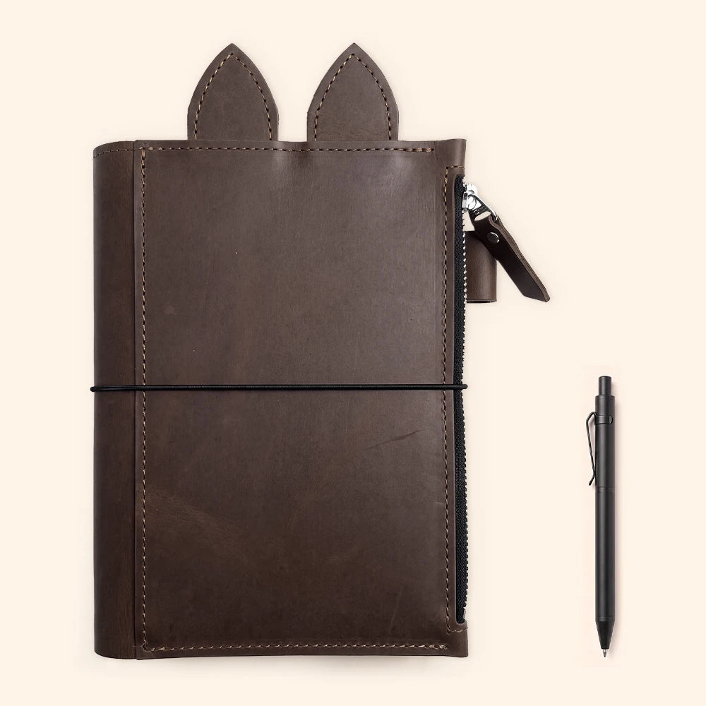 Leather notebook holder showing three separate elastic bands for multiple inserts.