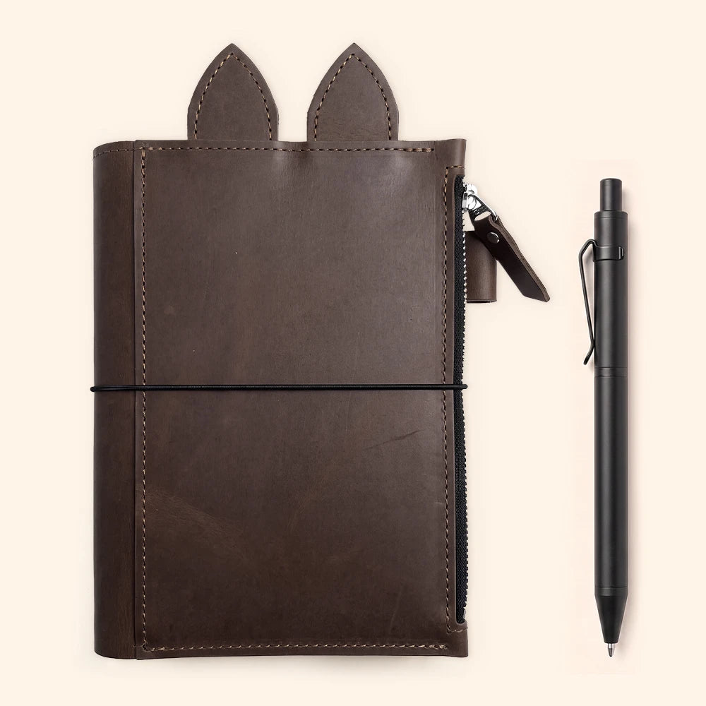 Open refillable planner cover showing three elastic bands for securely holding notebooks.