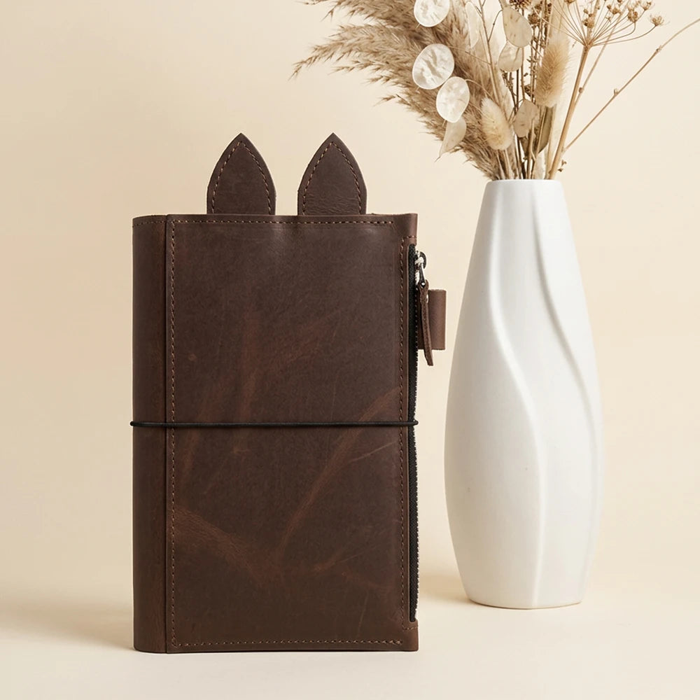 Handmade journal organizer showcasing rich leather grain and carefully stitched outer edges.