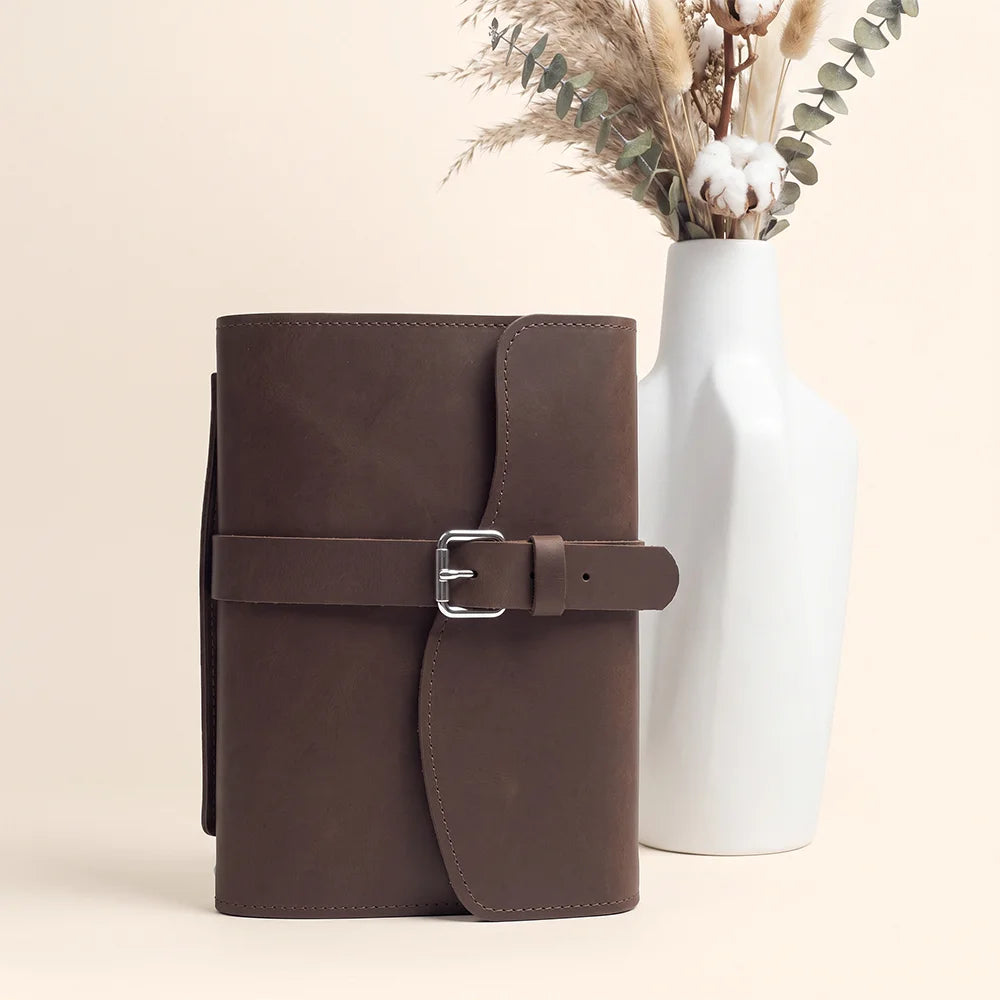 Leather journal cover designed with storage compartments, pen loop, ribbon marker, and external leather grip.