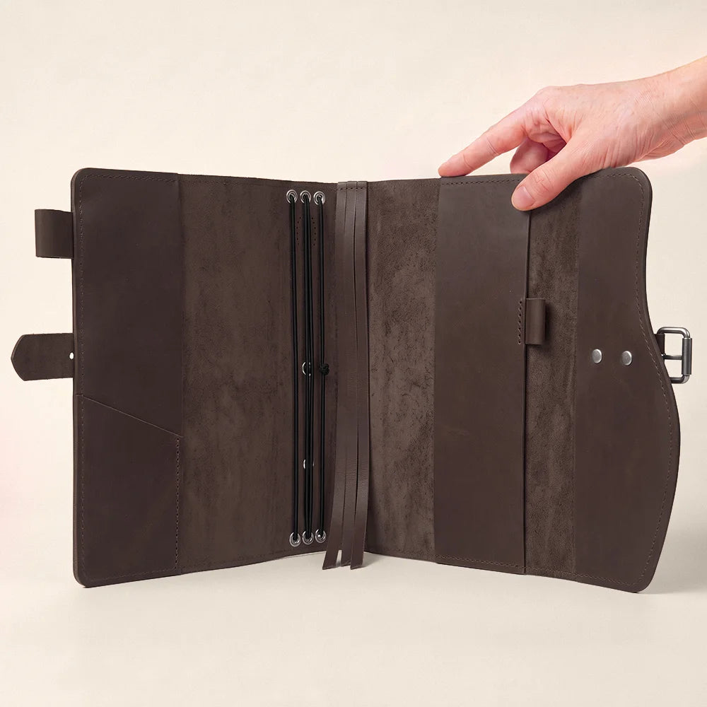 Handcrafted notebook sleeve with leather pockets, pen loop, integrated bookmark, and comfortable outside handle.