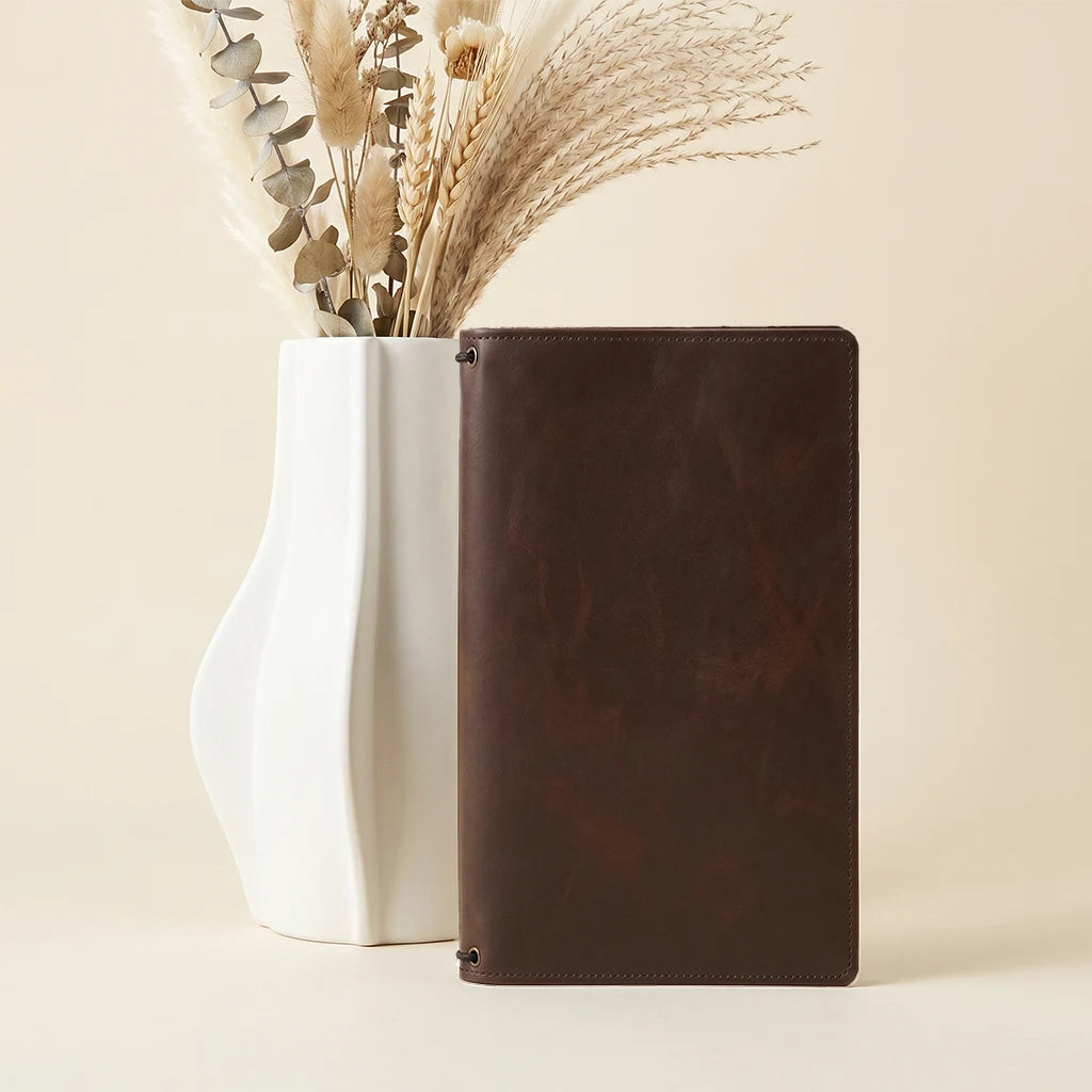 Hand-stitched leather journal cover with dedicated pockets for essentials inside.