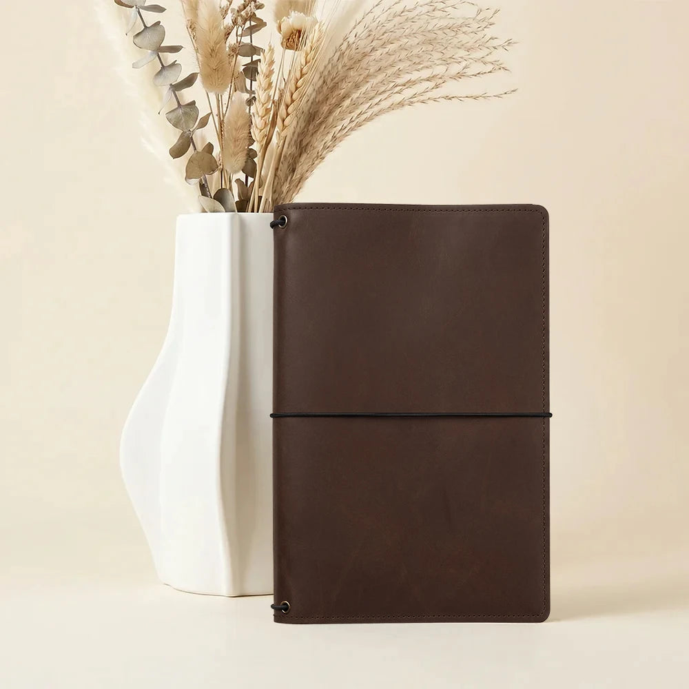 Refillable leather notebook sleeve with three elastic bands and interior card storage.