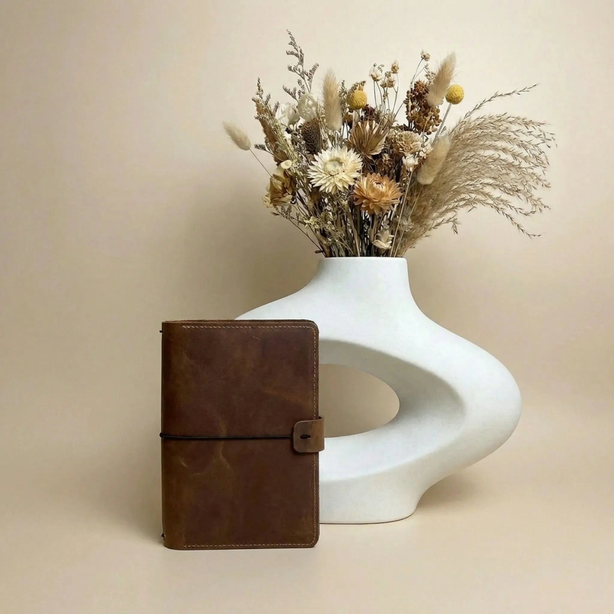 Leather notebook wallet featuring pen holder and inner storage compartments.
