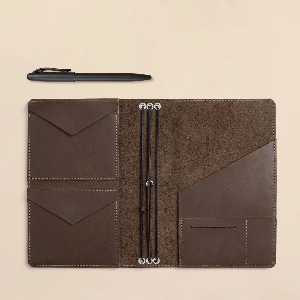 Leather notebook cover with built-in organizer compartments and elastic notebook securing system.