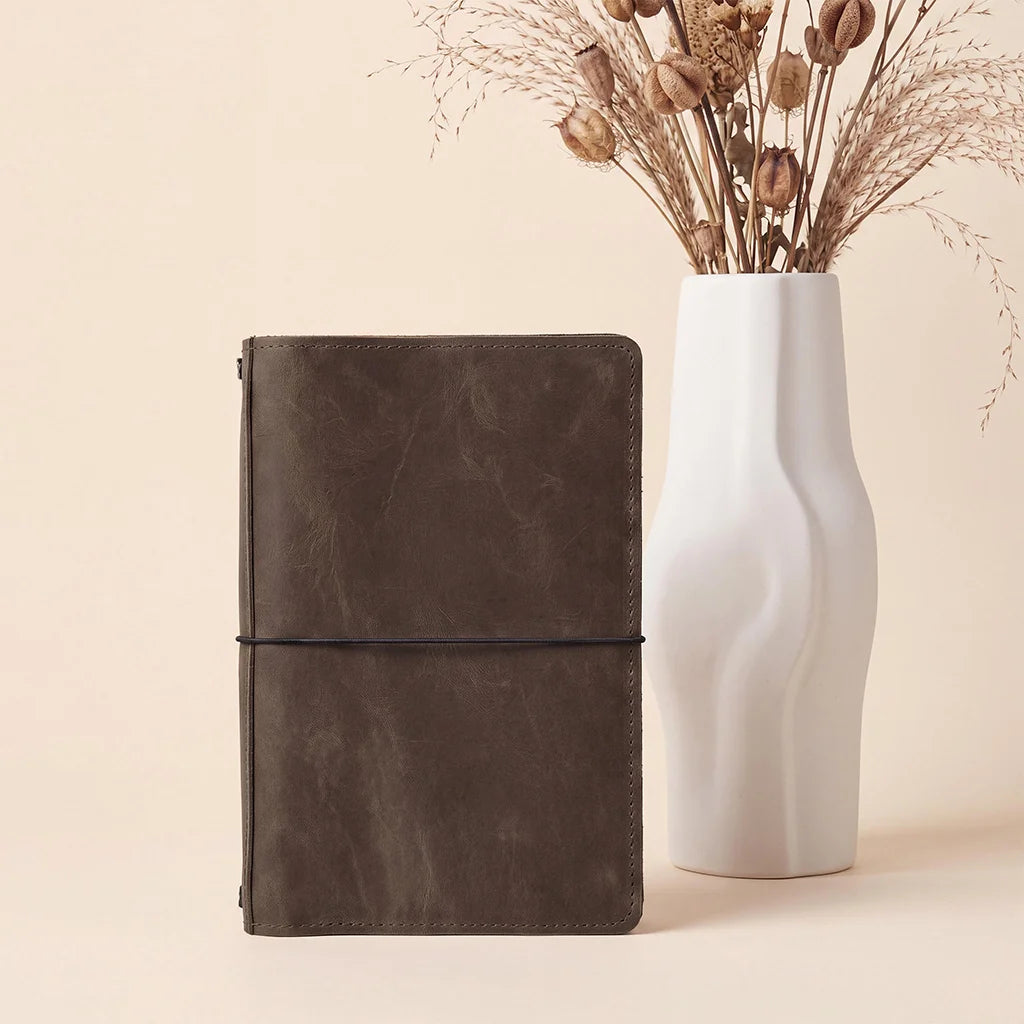 Genuine leather journal organizer for refillable notebooks with interior utility pockets.