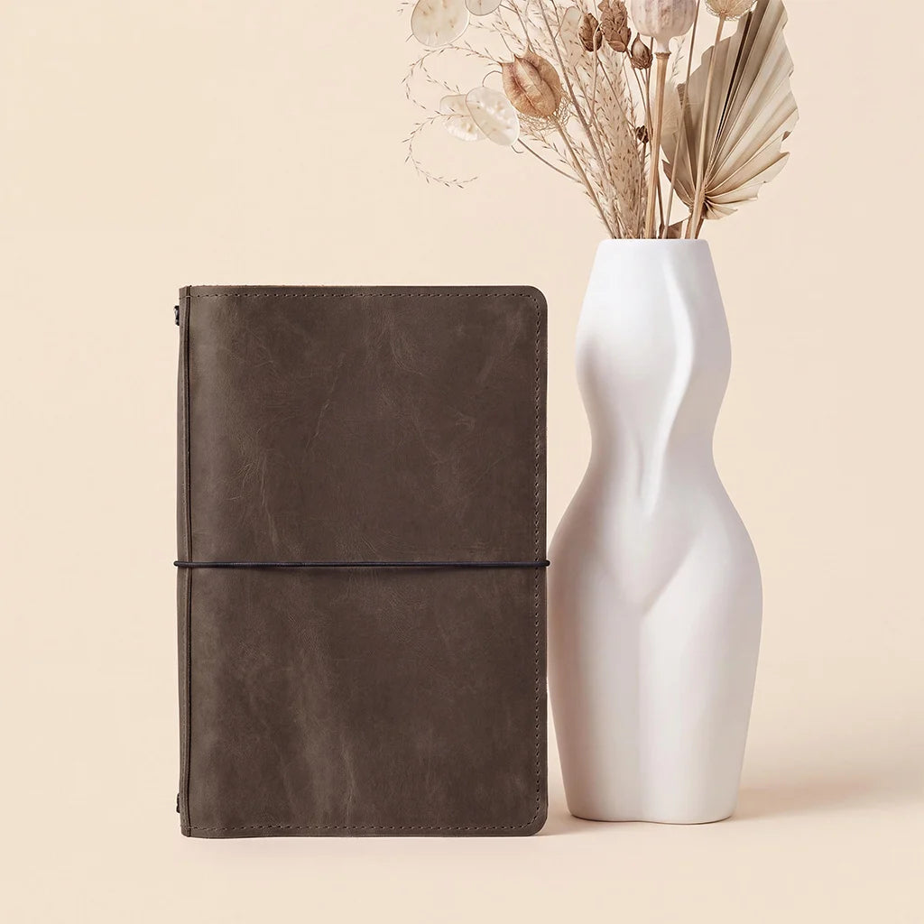 Premium leather journal cover designed with elastic bands and organized interior compartments.