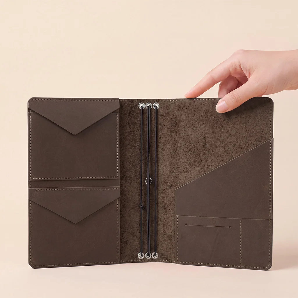 Refillable leather notebook organizer with handcrafted pockets and secure elastic insert system.