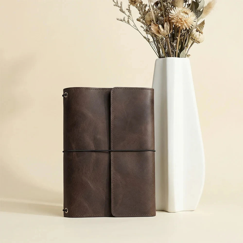 Brown leather notebook organizer featuring three elastic bands and useful interior card pockets.