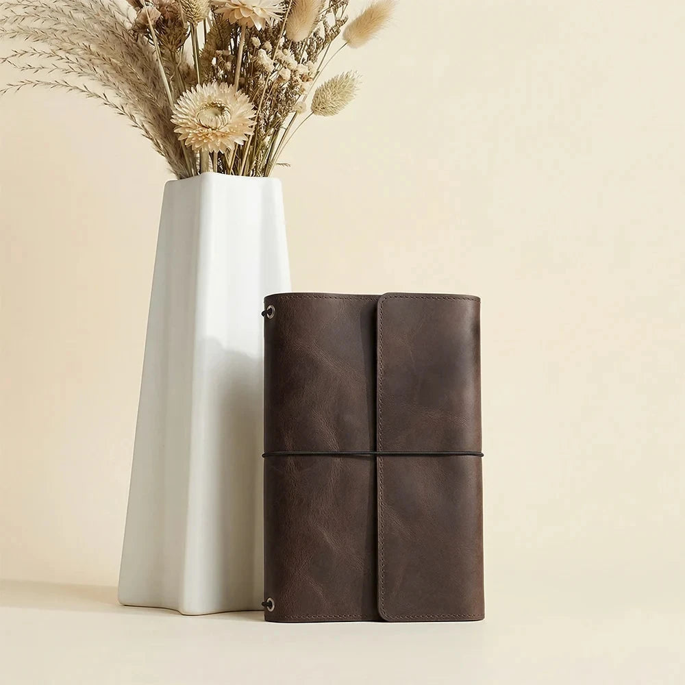 Handmade brown leather journal cover featuring three elastic bands and functional inside pockets.