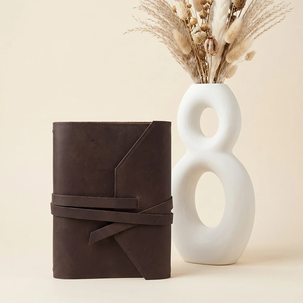 Stylish refillable leather journal cover with elastic fastening and pen holder loop.