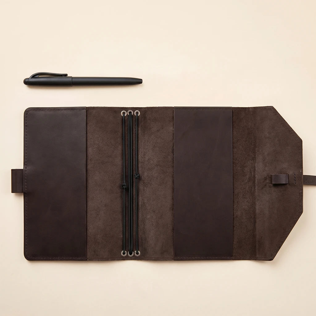 Leather notebook case offering refillable use, elastic straps and pen holder.