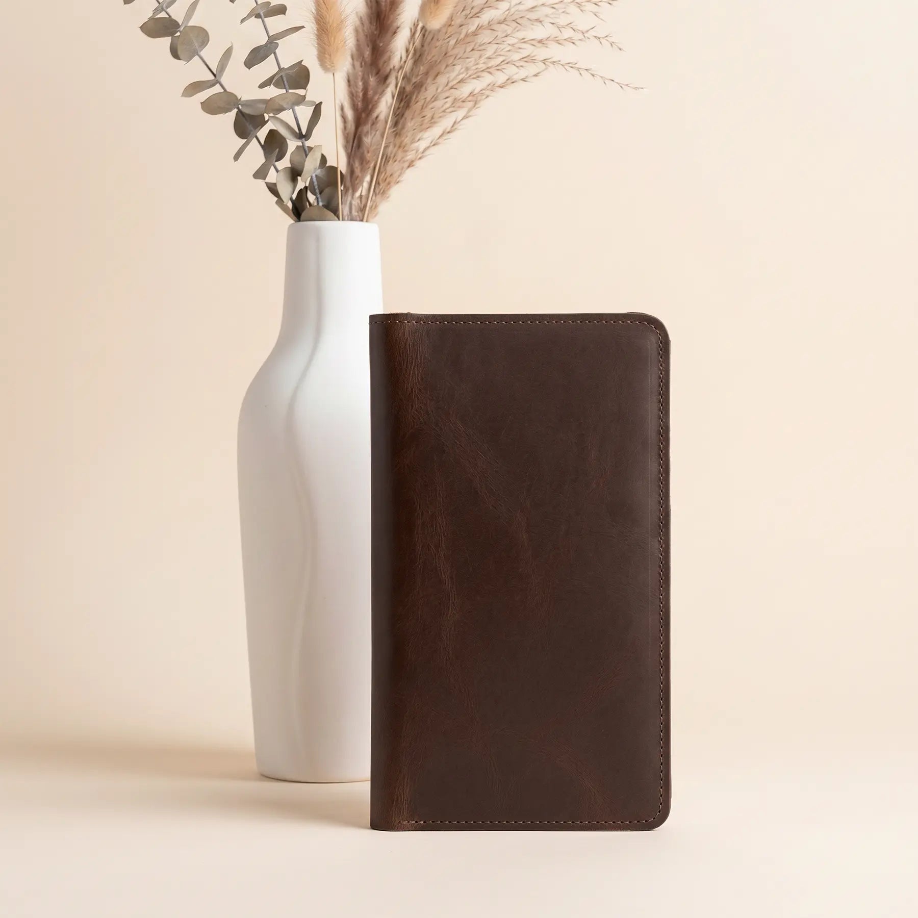 Premium handcrafted leather wallet offering secure button fastening, card slots, and interior zip pocket.