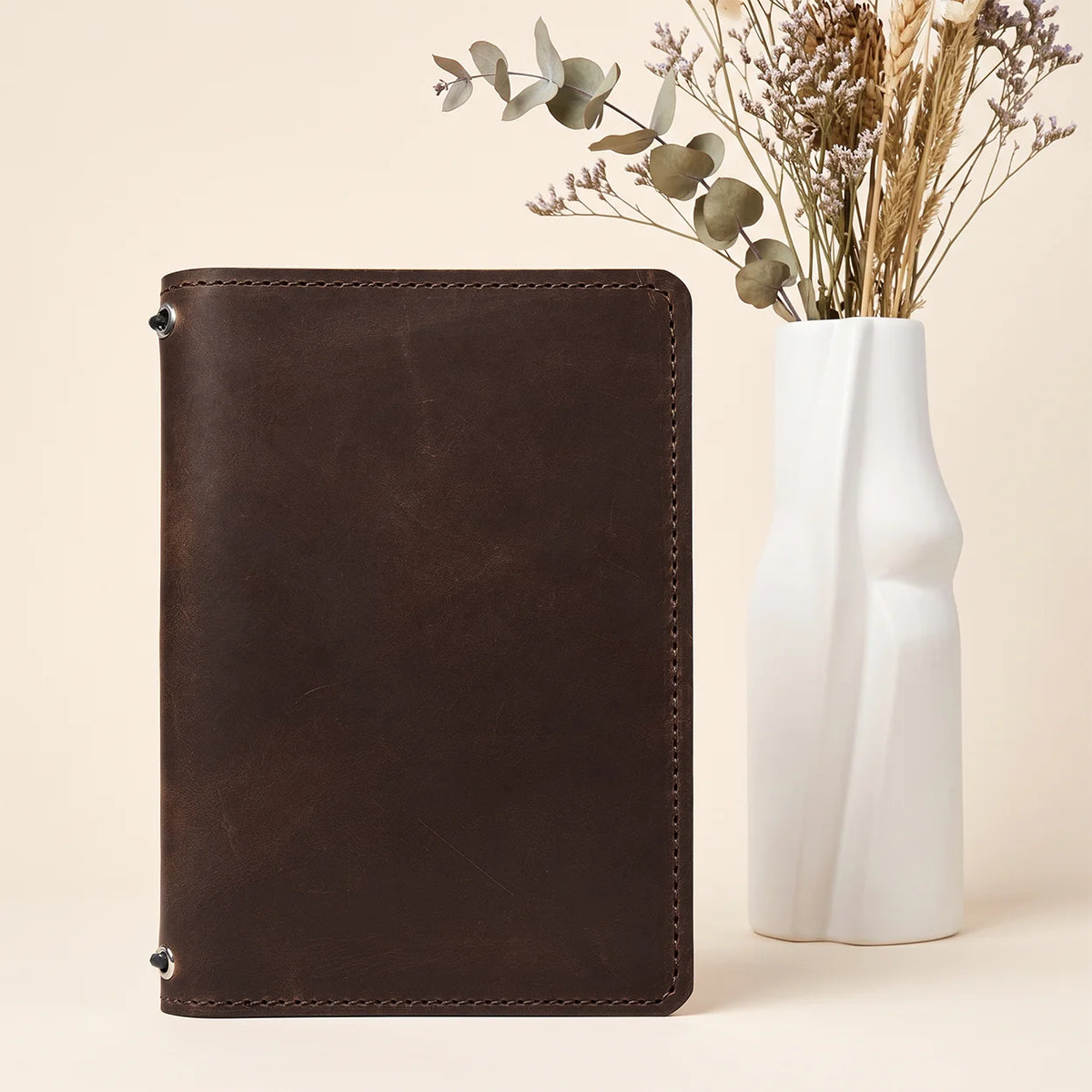 Rustic natural leather notebook holder featuring dual elastic straps and functional interior storage